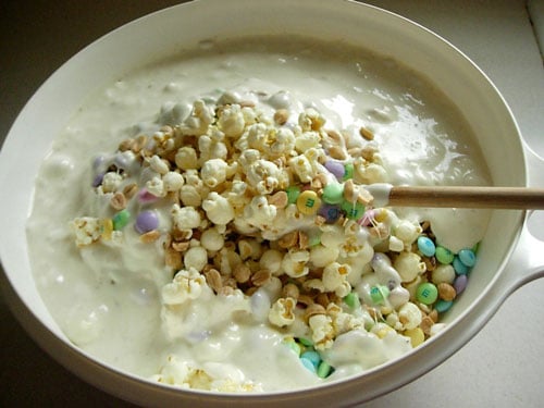Popcorn-Cake-recipe getting mixed How to make Popcorn-cake-recipe shown step by step. Mixing all the melted ingredients together.
