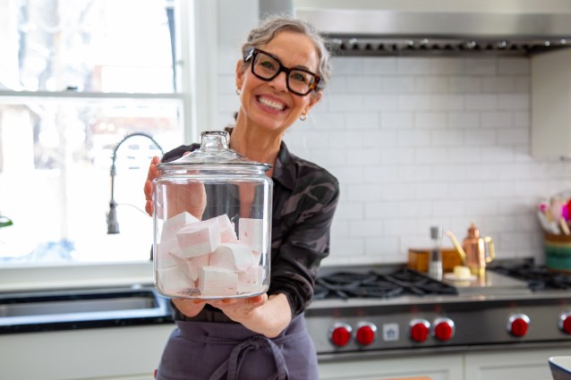 Host Zoe Francois holds a jar of marshmallows, as seen on Zoe Bakes, season 2.