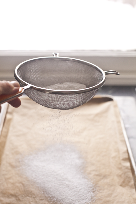 Dusting parchment with powdered sugar | how to make homemade marshmallows | photo by Zoë François