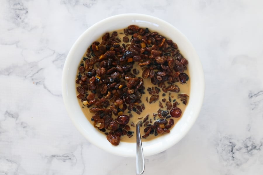 An overhead shot of a bowl of mixed dried fruit and iced coffee.