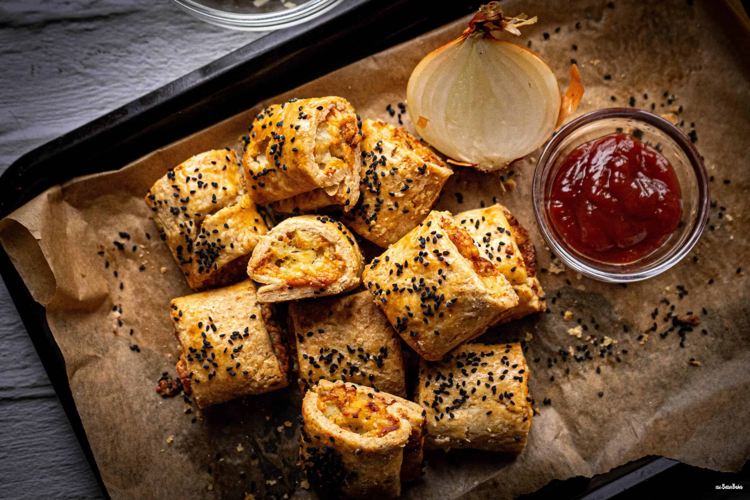 top shot of cheese and onion rolls next to cut onion and chilli sauce