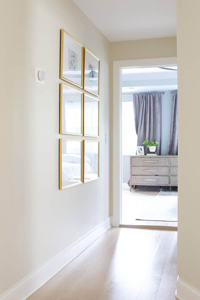 Adding a symmetrical gallery wall with gold frames to our upstairs hallway