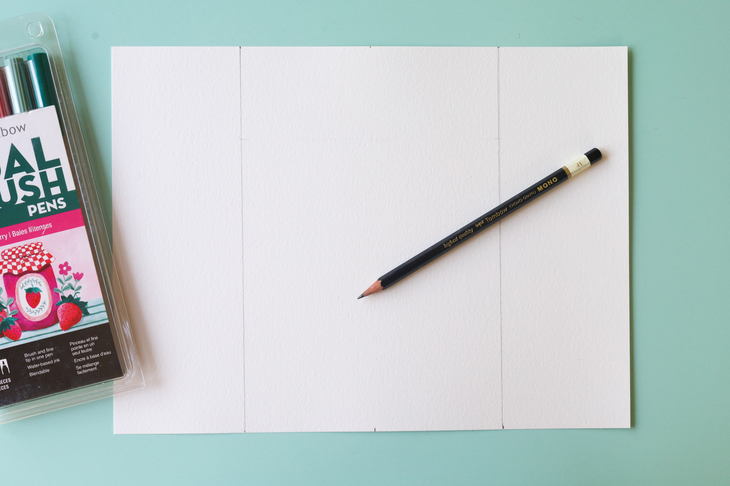 Start by using a ruler to create 2 vertical lines onto 1 piece of 9x12" watercolor paper. You want them 3" in from either side, so that the middle section is 6" wide.
