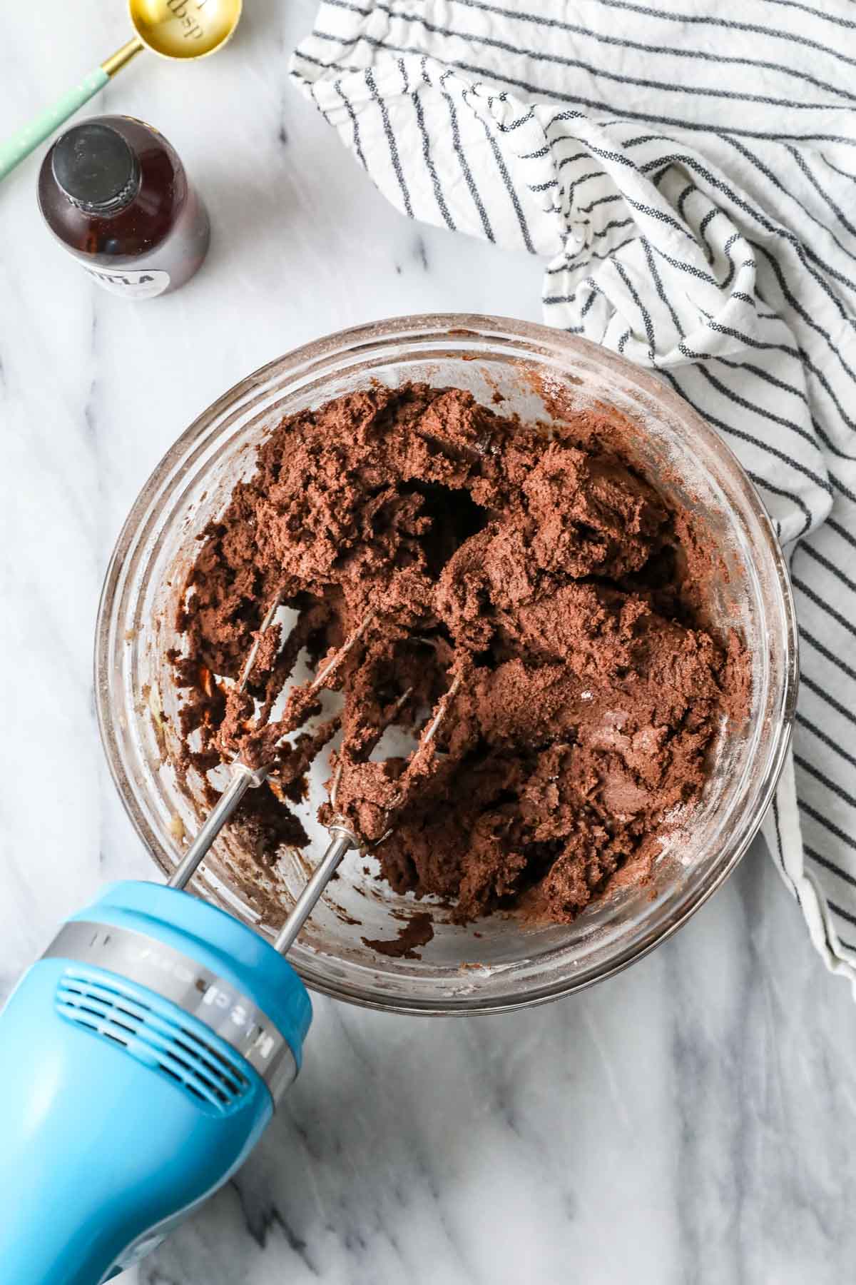 Overhead view of a mixer stirring a chocolate sugar cookie dough.