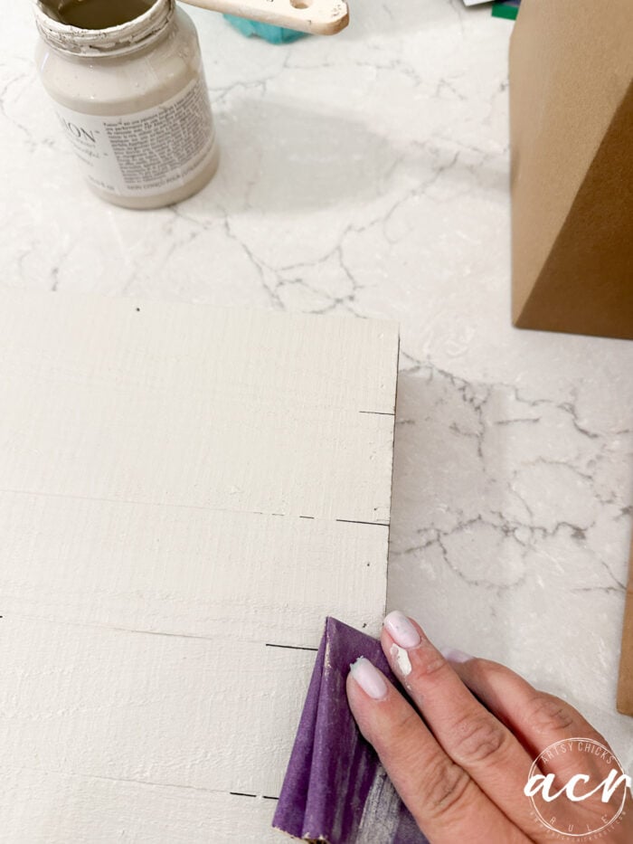 sanding edges of board sign