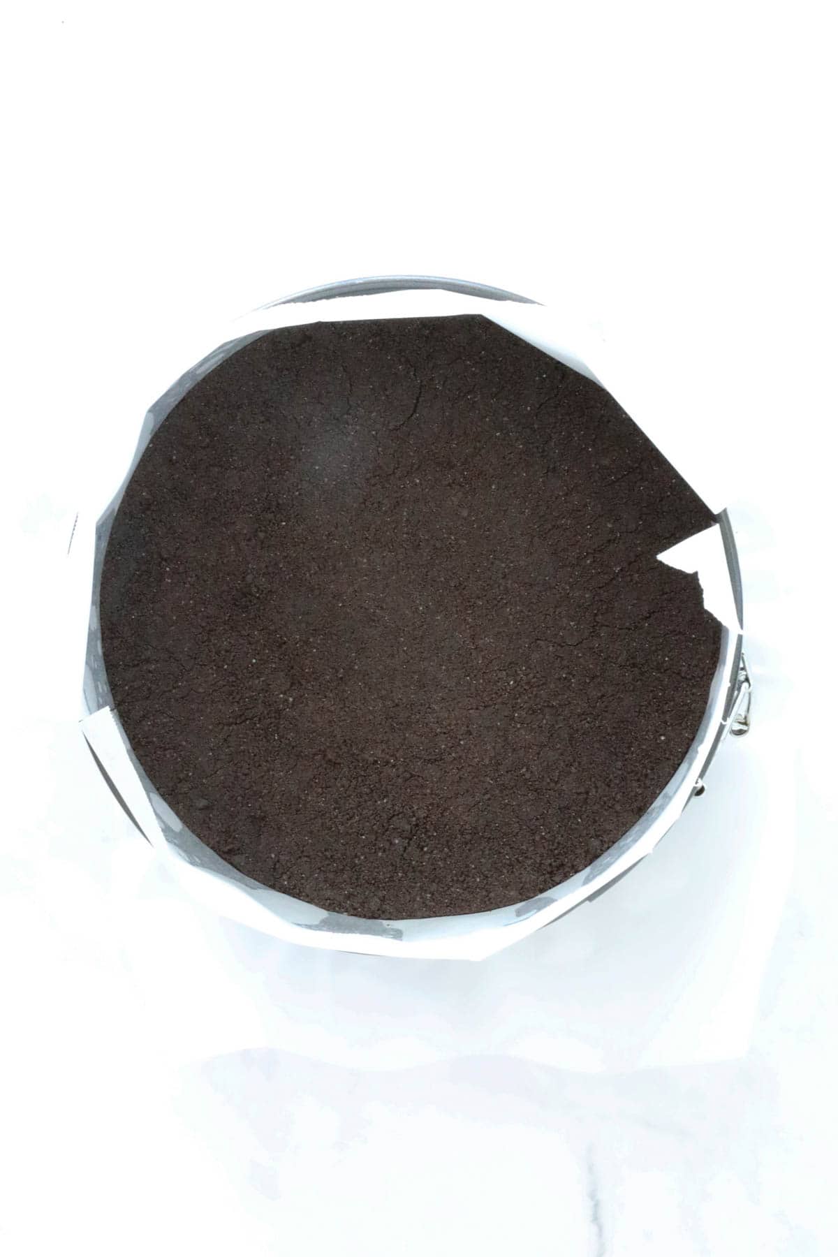 The Oreo mixture pressed down in the base of a lined tin.