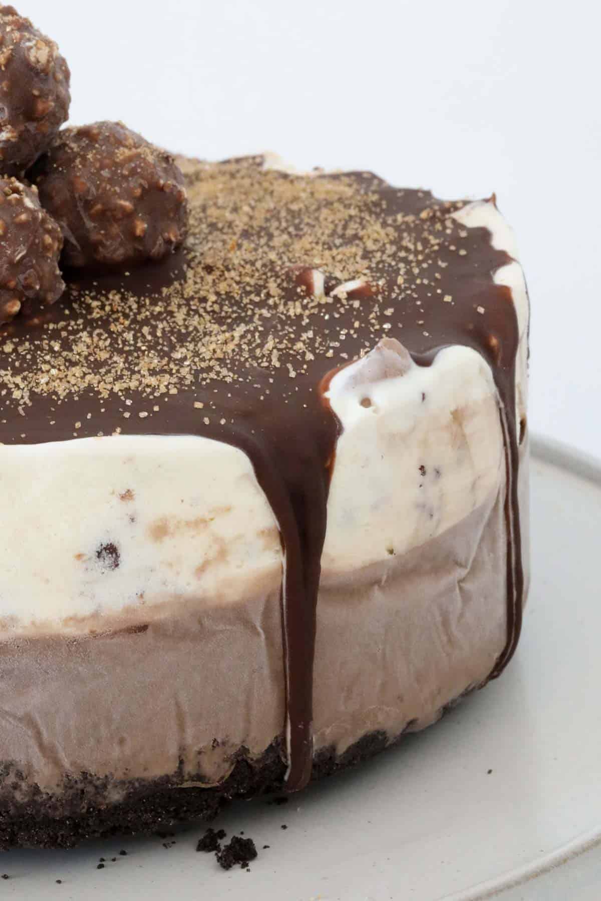 The frozen ice cream cake unwrapped and decorated with Ice Magic and Ferrero Rocher.