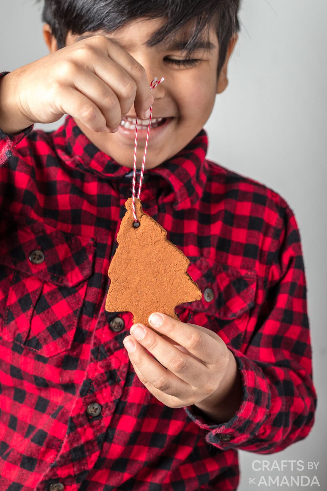 boy holding cinnamon ornament