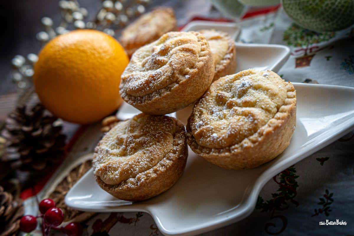 viennese mince pies on a christmas tree shaped plate surrounded by christmas decorations