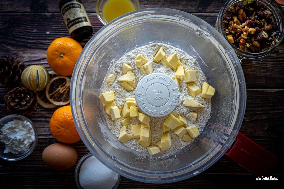cubed butter dotted over the flour and walnuts in a food processor bowl