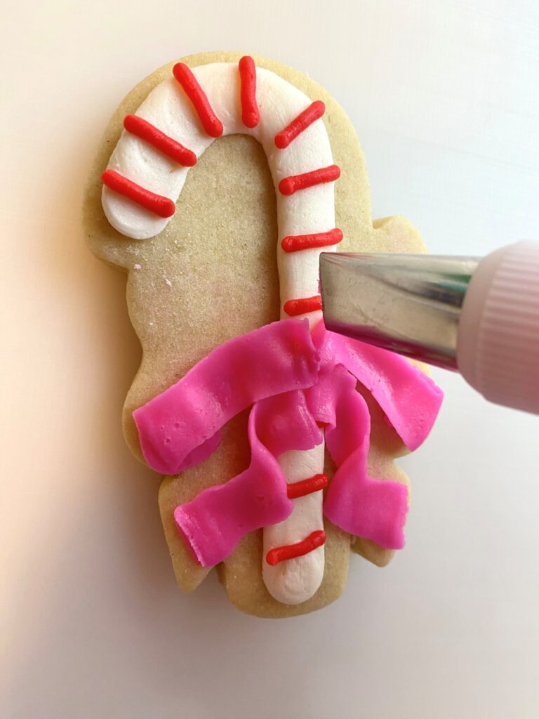 candy cane with bow decorated sugar cookie with buttercream