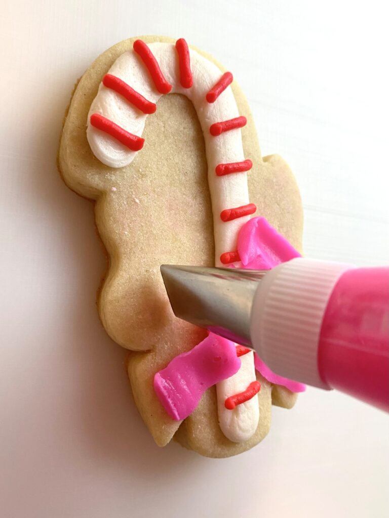 candy cane with bow decorated sugar cookie with buttercream
