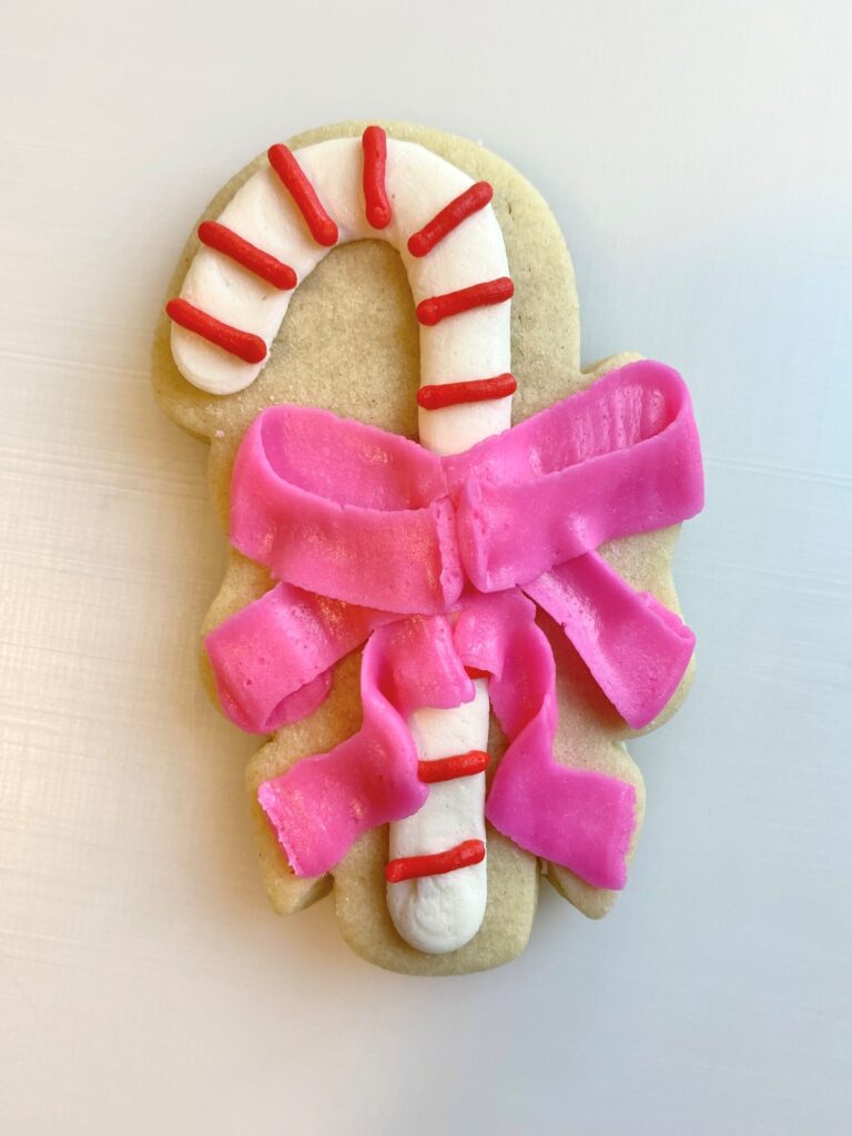 candy cane with bow decorated sugar cookie with buttercream