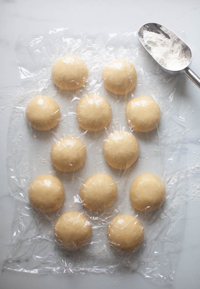 Sufganiyot dough resting under plastic wrap