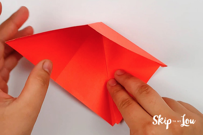 Two hands finishing the fold on the right hand side.