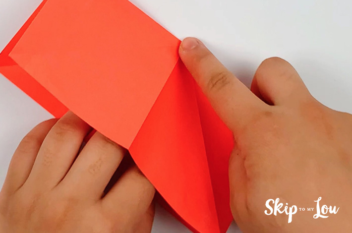 Two hands turning the paper.