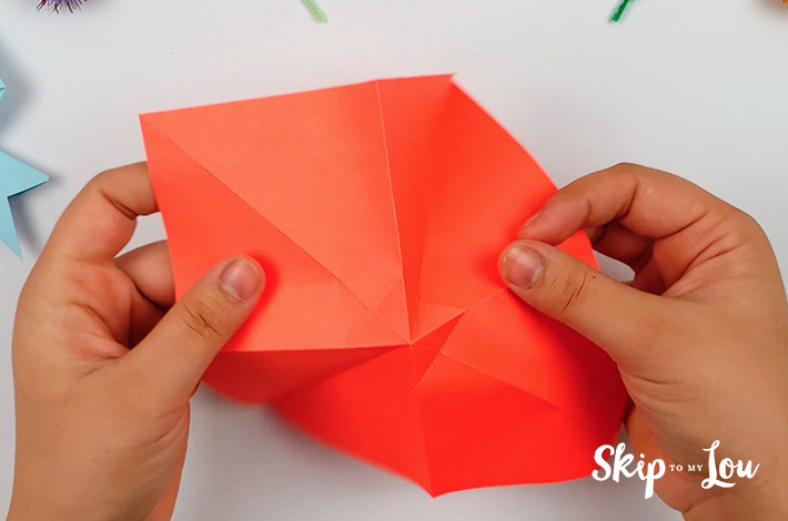 Two hand unfolding the paper.