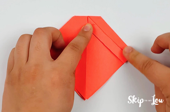 Two hands folding a flap on the right side.