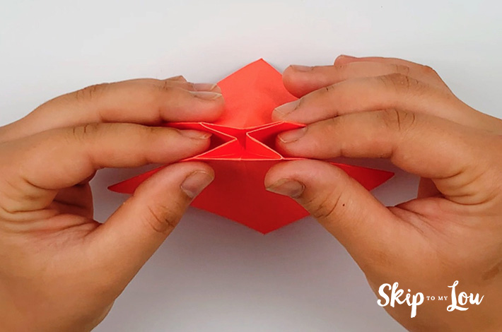 Two hands flattening the piece of paper.
