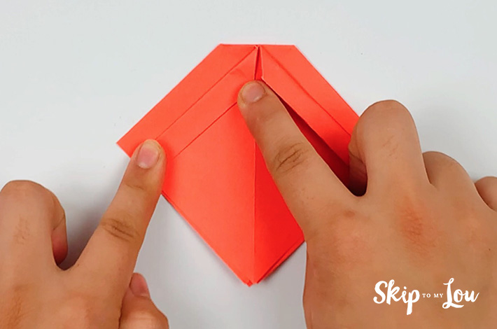 Two hands folding a flap on the left side.