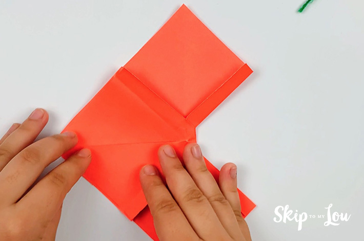 Two hands lining up the left flap with the right flap.