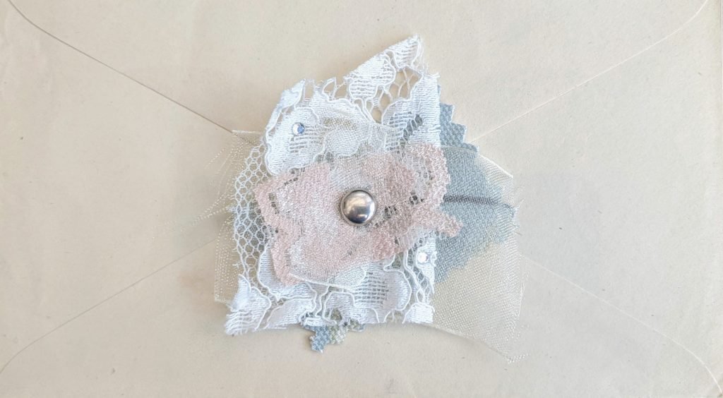 Pink fabric cluster on a vintage envelope