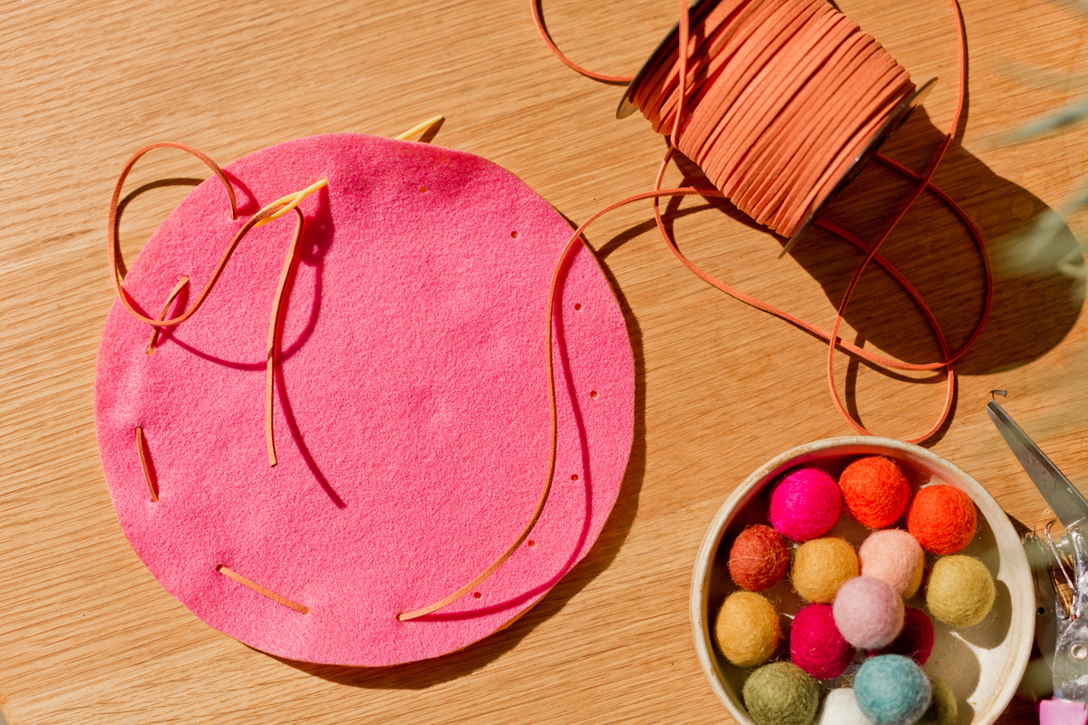 making felt pouch, sewing needle and thread through circle felt pieces