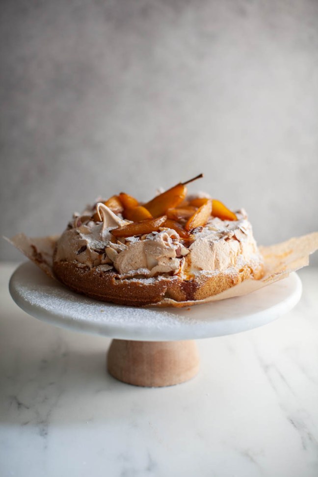 Meringue Cake with Roasted Pears on a cake stand